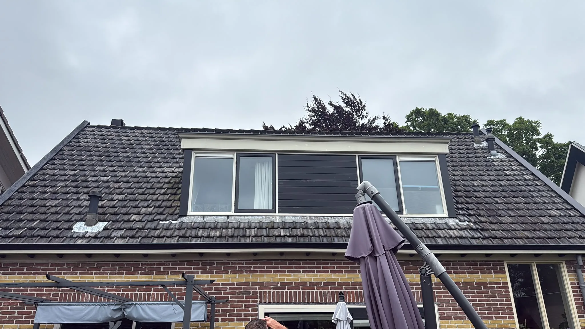 Nieuw dak op bakstenen woonhuis met dakramen