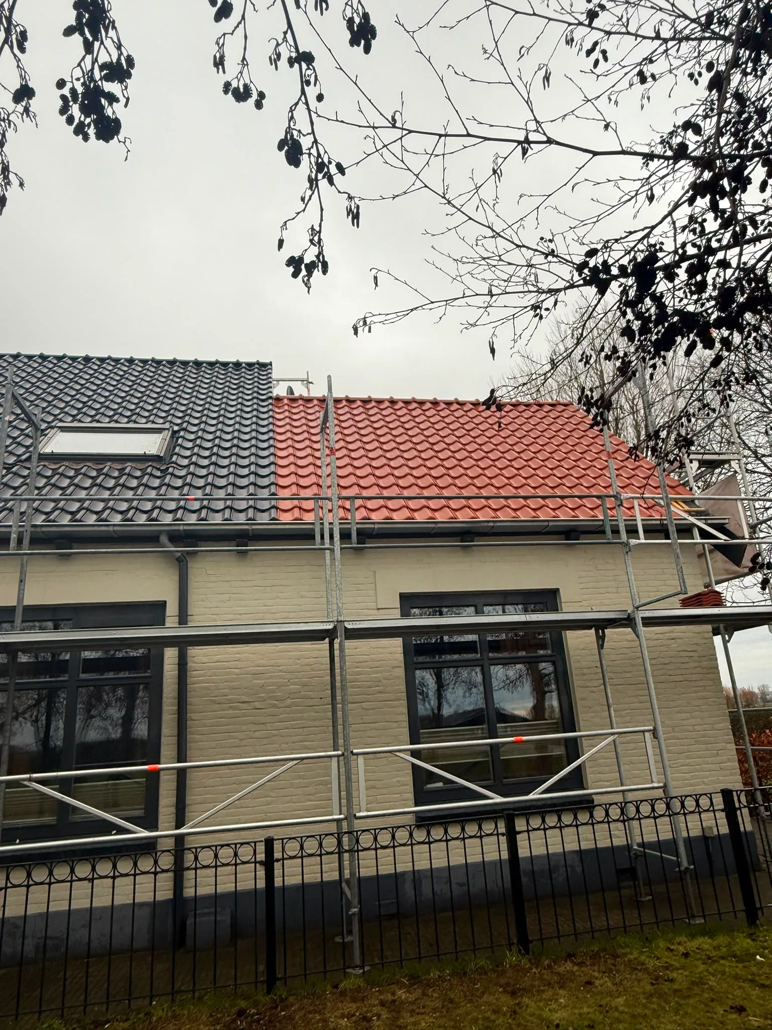 Huisvoorgevel met nieuw rood dak gerenoveerd