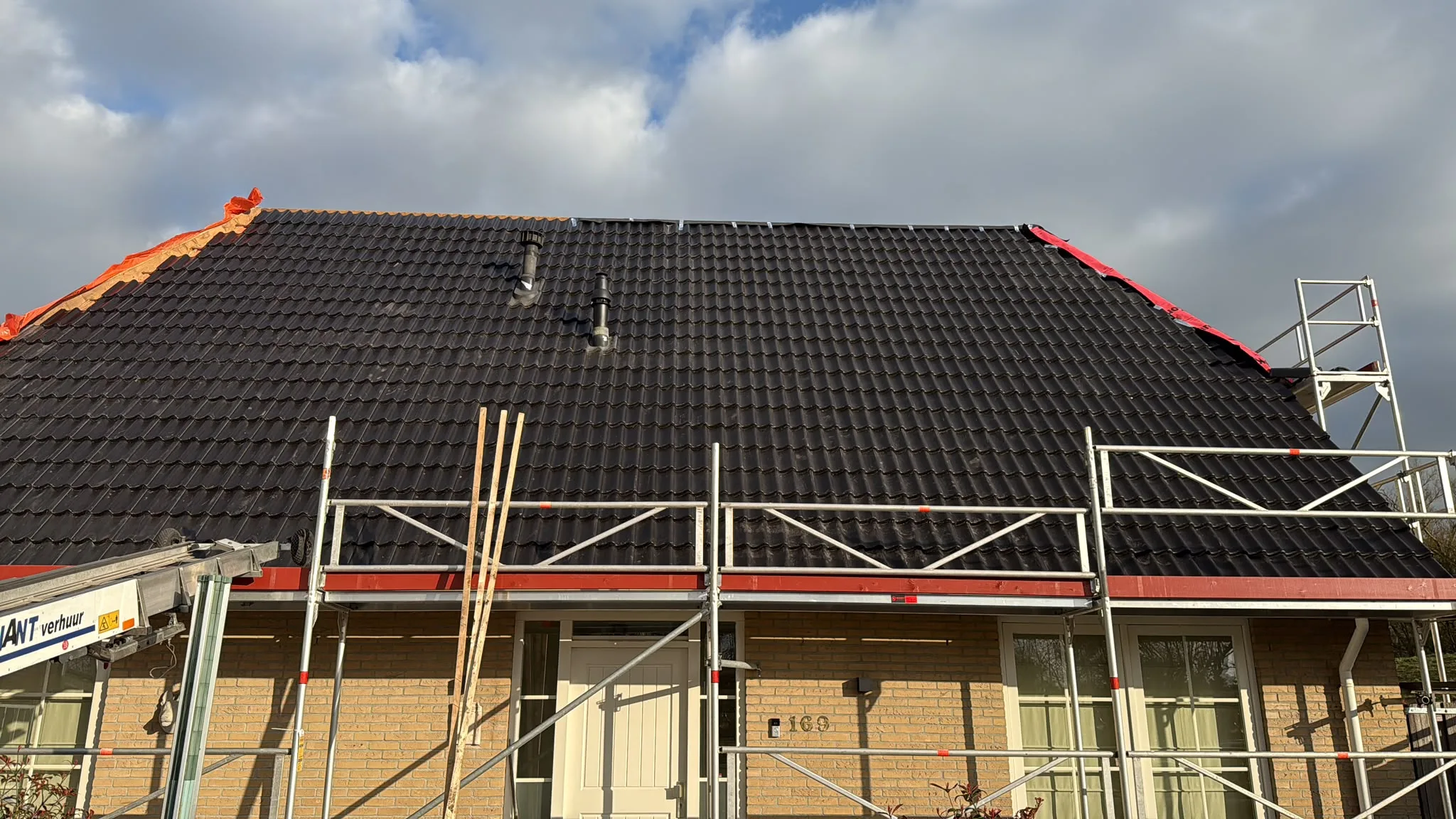 Dakrenovatie met nieuw zwart dak en steigers