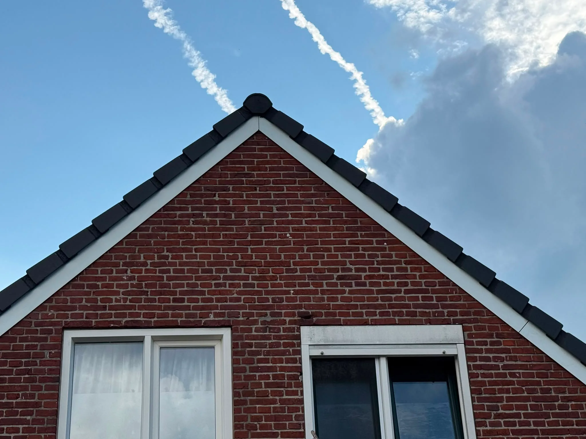 Bakstenen woning met zwart gerenoveerd dak