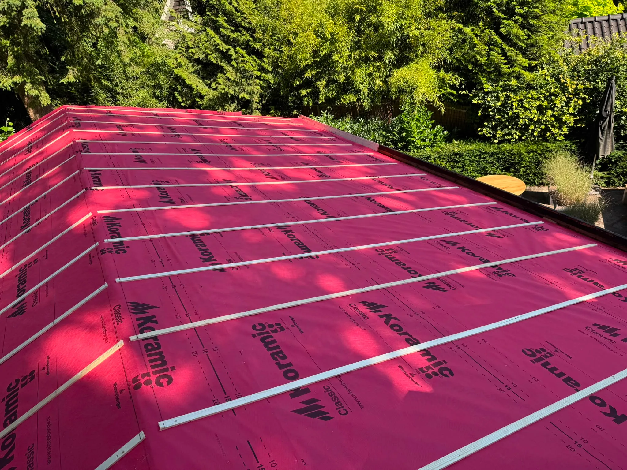 Dakrenovatie met rood beschermingsmateriaal
