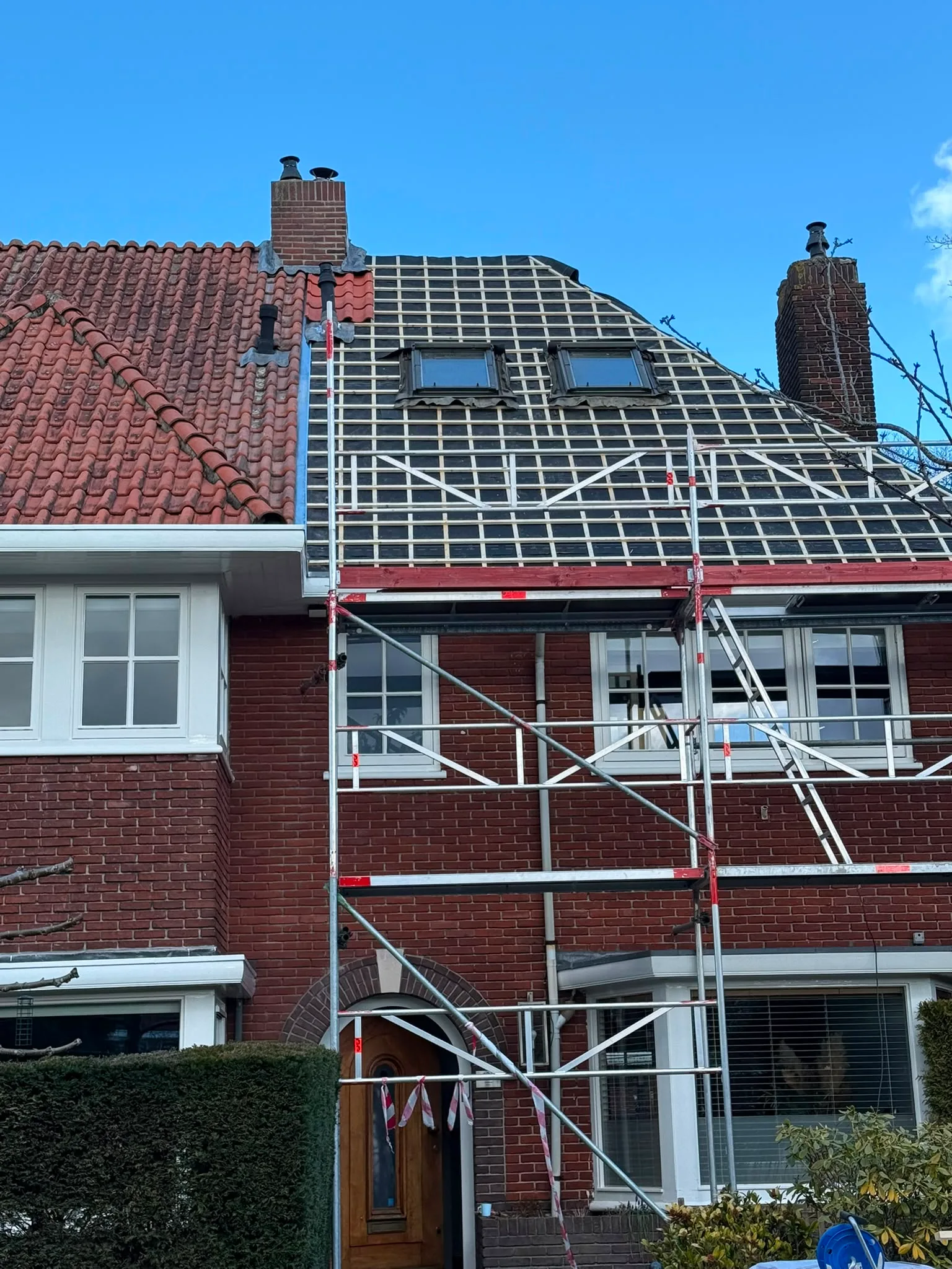 Bakstenen woning met dakrenovatie en steigers