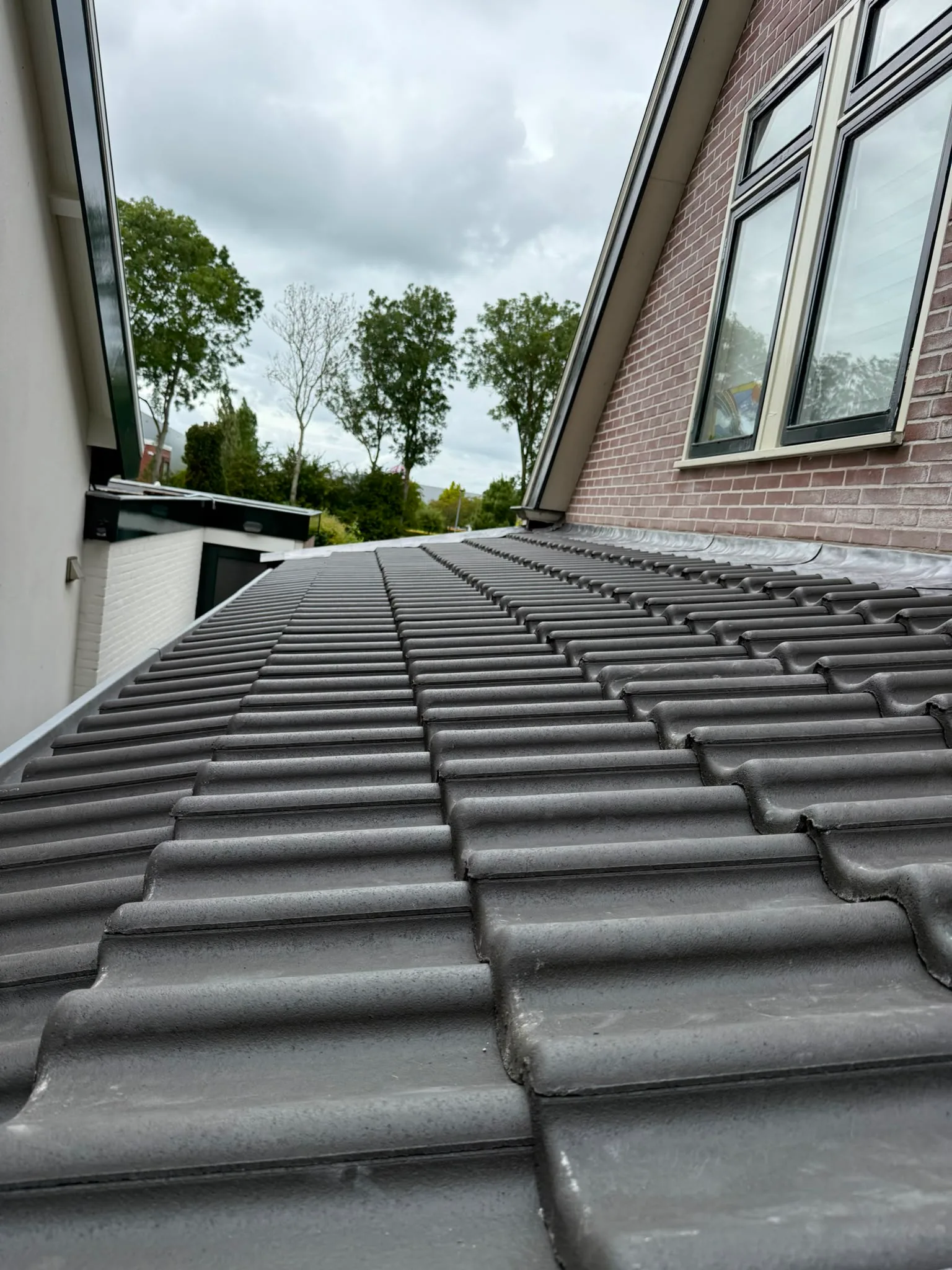 Gerenoveerd dak met donkere dakpannen