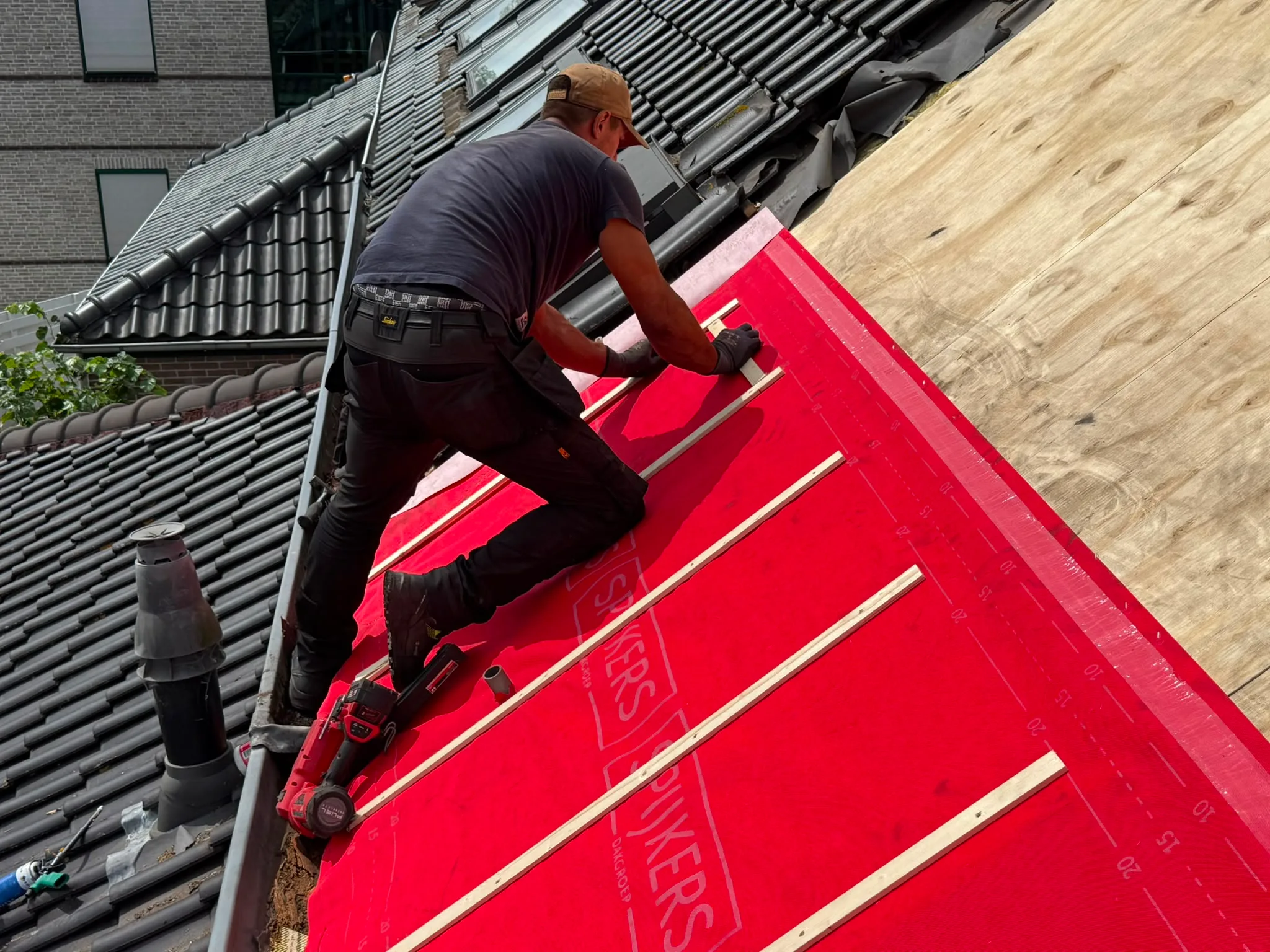Installatie rode dakbekleding op woning